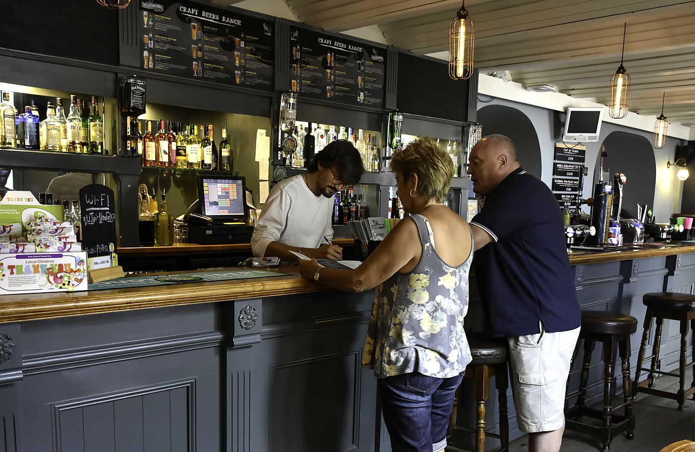 Staff serving customers at the bar of the Captains Table, Saundersfoot