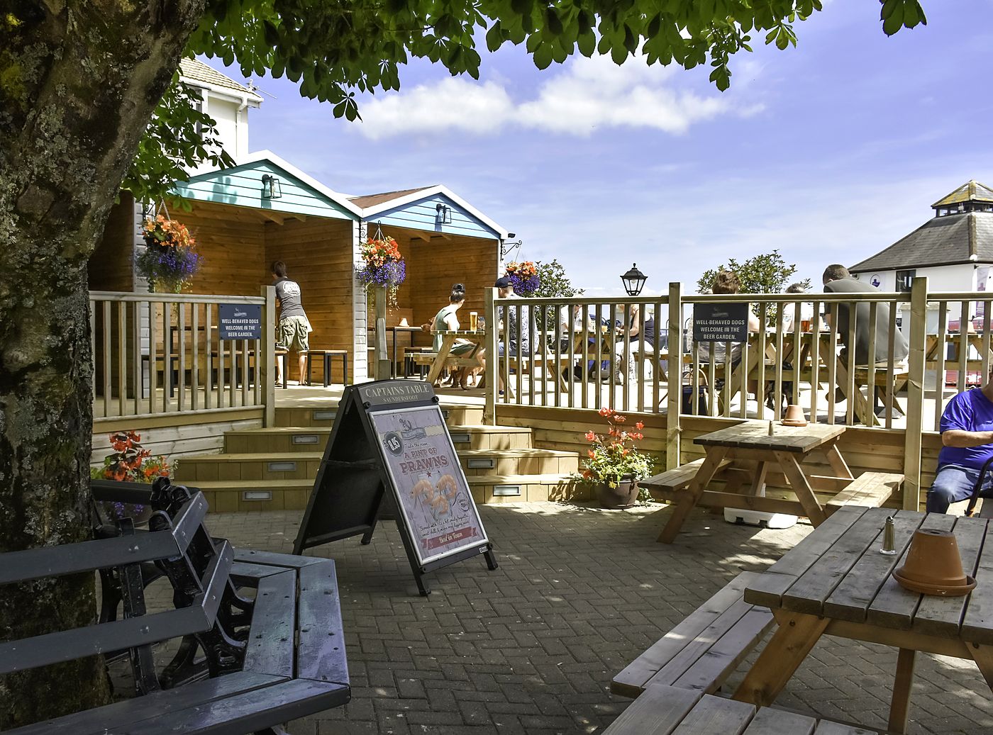 Beach huts and picnic tables in the Captains Table beer garden, Saundersfoot